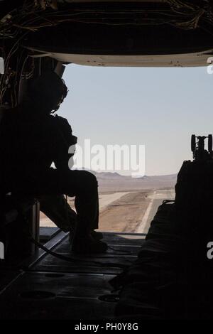 Cpl. Chase Clark, ein tiltrotor Crew Chief mit Marine Medium Tiltrotor Squadron 764, Marine Flugzeuge Gruppe 41, 4 Marine Flugzeugflügel, sieht die Rückseite einer MV-22 Osprey B während der integrierte Ausbildung Übung 4-18, in der Marine Corps Air Ground Combat Center Twentynine Palms, Calif., 23. Juni 2018. VMM-764, wie "Moonlight" bekannt, ist aus der Marine Corps Air Station Miramar und Air Combat element Unterstützung bei ITX 4-18 zu Marine Air Ground Task Force 23. Stockfoto