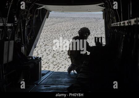 Cpl. Chase Clark, ein tiltrotor Crew Chief mit Marine Medium Tiltrotor Squadron 764, Marine Flugzeuge Gruppe 41, 4 Marine Flugzeugflügel, bereitet die MV-22 Osprey B an Bord Marines während der integrierte Ausbildung Übung 4-18, in der Marine Corps Air Ground Combat Center Twentynine Palms, Calif., 23. Juni 2018. VMM-764, wie "Moonlight" bekannt, ist aus der Marine Corps Air Station Miramar und Air Combat element Unterstützung bei ITX 4-18 zu Marine Air Ground Task Force 23. Stockfoto