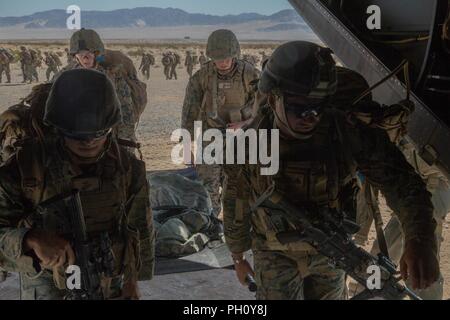 Marines mit Waffen Firma, 1.Bataillon, 25 Marine Regiment, 4 Marine Division, ein MV-22 B Osprey, während integrierte Ausbildung Übung 4-18 begeben, bei der Marine Corps Air Ground Combat Center Twentynine Palms, Calif., 23. Juni 2018. VMM-764, wie "Moonlight" bekannt, ist aus der Marine Corps Air Station Miramar und Air Combat element Unterstützung bei ITX 4-18 zu Marine Air Ground Task Force 23. Stockfoto