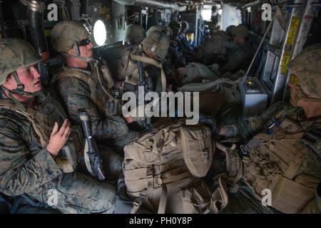 Marines mit Waffen Firma, 1.Bataillon, 25 Marine Regiment, 4 Marine Division, fliegen in einem MV-22 Osprey B für eine Luft ein, während integrierte Ausbildung Übung 4-18 bei Marine Corps Air Ground Combat Center Twentynine Palms, Calif., 23. Juni 2018. VMM-764, wie "Moonlight" bekannt, ist aus der Marine Corps Air Station Miramar und Air Combat element Unterstützung bei ITX 4-18 zu Marine Air Ground Task Force 23. Stockfoto