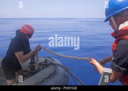 Mittelmeer (21. Juni 2018) Der Bootsmann Mate Seaman Apprentice Kale Kisling, von Sioux City, Iowa, Hände die stetigen Linie Seaman Cody von unten, von Virginia Beach, Virginia, während kleine Boot Operationen an Bord der San Antonio-Klasse amphibious Transport dock Schiff USS New York (LPD-21) 21. Juni 2018. New York, homeported in Mayport, Florida, ist die Durchführung von naval Operations in den USA 6 Flotte Bereich der Maßnahmen zur Unterstützung der US-amerikanischen nationalen Sicherheitsinteressen in Europa und Afrika. Stockfoto