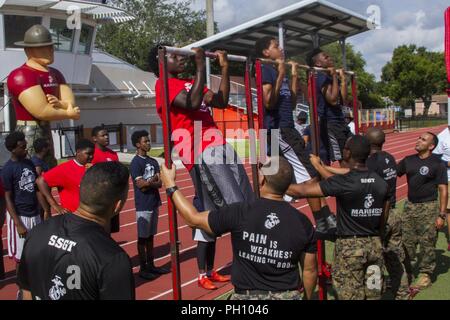 Marine Corps recruiters mit einziehenden Station (RS) Fort Lauderdale, Prüfung des Teilnehmers Pull-ups während des United States Marine Corps Sport Leadership Academy in Fort Lauderdale, Florida, 23. Juni 2018. Die Leadership Academy ist für Sportler die Grundlagen des Marine Corps Führung zu lehren und lernen Techniken und Skillsets für einen bestimmten Sport. Stockfoto