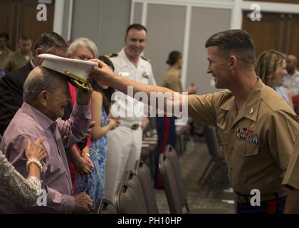 Oberst Jeffrey C. Smitherman, Kommandierender Offizier der 6. Marine Corps Bezirk, Hände seinen Brief an die Telefonzentrale des einziehenden Station (RS) Jacksonville Ändern des Befehls Zeremonie in Jacksonville, Florida, 22. Juni 2018. Während der Zeremonie, Maj. Michael Valenti, der scheidende Kommandeur für RS Jacksonville, wird seinen Befehl an Maj. Joseph Gill verzichten. Stockfoto