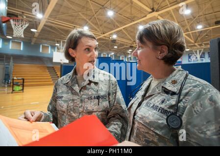 Us Air Force Oberstleutnant Patricia Adams (links), ein optometriker von 123. Airlift Wing die Kentucky der Air National Guard, bespricht die Patientenversorgung mit US Air Force Maj. Tiffany Hubbard, ein Krankenschwesterpraktiker, Gesundheitswesen Klinik durch die Air Guard und US Navy Reserve im Lee County High School in Beattyville, Ky., 20. Juni 2018 ausgeführt werden. Die beattyville Klinik ist einer von vier, die aus Betrieb Bobcat, einer 10-tägigen Mission militärischen medizinischen Truppen mit entscheidenden Ausbildung im Bereich Operations und Logistik zur Verfügung und bietet kostenlose Gesundheitsversorgung für die Bewohner der östlichen Kentucky. Die c Stockfoto