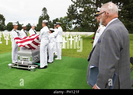 Normandie, Frankreich (19. Juni 2018) Die U.S. Naval Hospital Neapel Ehrengarde hält die amerikanische Flagge über die Überreste von Radioman 2. Klasse Julius "Henry" Pieper während seiner Trauerfeier Normandie an der Amerikanischen Friedhof. Henry Pieper und seinem Zwillingsbruder, Radioman 2. Klasse Ludwig "Louie" Pieper, waren beide getötet, als ihr Schiff, Landing Ship Tank (LST) 523, schlug eine vor der Küste von Frankreich am 19. Juni 1944. Louie's Überreste wurden sofort gefunden, aber Henry's Überreste wurden nicht bis Dezember 2017 identifiziert. Die Familie beantragt, dass Henry in der Normandie neben seinem Bruder begraben werden. Stockfoto