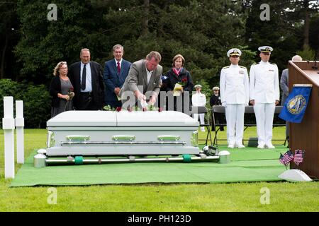 Normandie, Frankreich (19. Juni 2018) Mitglieder der Familie von Radioman 2. Klasse Julius "Henry" Pieper, Rosen und Sand von Omaha Beach auf Pieper's Sarg während seiner Trauerfeier Normandie an der Amerikanischen Friedhof. Henry Pieper und seinem Zwillingsbruder, Radioman 2. Klasse Ludwig "Louie" Pieper, waren beide getötet, als ihr Schiff, Landing Ship Tank (LST) 523, schlug eine vor der Küste von Frankreich am 19. Juni 1944. Louie's Überreste wurden sofort gefunden, aber Henry's Überreste wurden nicht bis Dezember 2017 identifiziert. Die Familie beantragt, dass Henry in der Normandie begraben neben seinem Bruder. Stockfoto