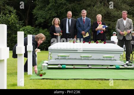 Normandie, Frankreich (19. Juni 2018) Radioman 2. Klasse Julius "Henry" Pieper's Nichte, Susan Lawrence, Orte eine Rose auf das Grab von Doppel Pieper's Bruder, Radioman 2. Klasse Ludwig "Louie" Pieper, während der Trauerfeier für Henry Pieper Normandie an der Amerikanischen Friedhof. Henry und Louie Pieper waren beide getötet, als ihr Schiff, Landing Ship Tank (LST) 523, schlug eine vor der Küste von Frankreich am 19. Juni 1944. Louie's Überreste wurden sofort gefunden, aber Henry's Überreste wurden nicht bis Dezember 2017 identifiziert. Die Familie beantragt, dass Henry in der Normandie begraben neben seinem Bruder. Stockfoto