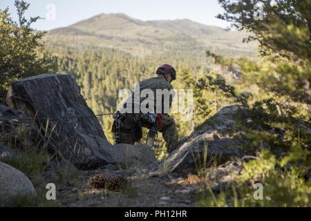 Eine Aufklärung Marine mit 4 Reconnaissance Battalion, 4th Marine Division, Uhren, um sicherzustellen, dass ein Marine sicher rappels auf einer Klippe, während Berg Übung 3-18, am Berg Warfare Training Center, Bridgeport, Calif., 20. Juni 2018. Nach Abschluss der Übung 4-17 letztes Jahr, 4 Reconnaissance Bataillon nahmen an MTX3-18 Kleinmaßeinheit Führung weiter zu entwickeln und ein Verständnis für die verschiedenen Klimazonen und Szenarien, die Sie in der Zukunft haben könnten. Stockfoto