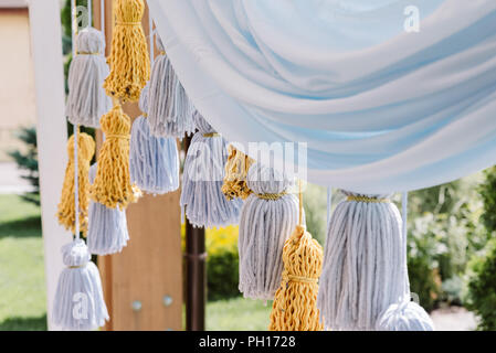 Handmade elegante Hochzeit Dekor. Quasten aus Thread auf eine festliche Photozone Stockfoto