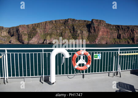 Die Northlink Fähre MV Hamnavoe vorbei an den Klippen von St John's Kopf, der Bug von Brae Brough rechts von der Mitte, auf Hoy, Orkney Stockfoto