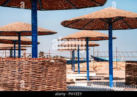 Bambus Sonnenschirm am Strand gypten. Sonnenschirm auf dem Hintergrund des  blauen Himmels Stockfotografie - Alamy