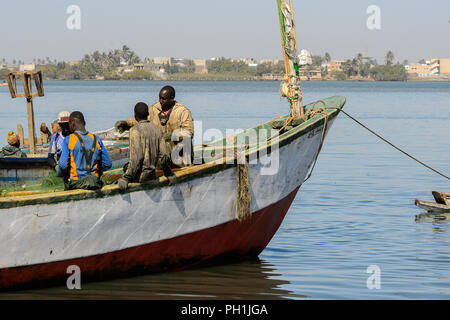 SAINT LOUIS, SENEGAL - Apr 24, 2017: Unbekannter senegalesischen Männer Segel auf dem Schiff in den Hafen von Saint Louis, eine der größten Städte in Senegal Stockfoto