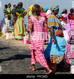 SAINT LOUIS, SENEGAL - Apr 24, 2017: Unbekannter senegalesischen Frauen in farbigen traditionelle Kleidung in den Hafen von Saint Louis, einer der größten Stand Stockfoto