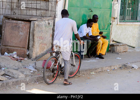 SAINT LOUIS, SENEGAL - Apr 24, 2017: Unbekannter senegalesischen Mann reitet ein Fahrrad in Saint Louis, eine der größten Städte in Senegal Stockfoto