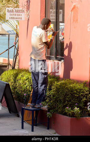 SAINT LOUIS, SENEGAL - Apr 24, 2017: Unbekannter senegalesischen Mann Reparaturen das Kabel in der Nähe der Fenster in St. Louis, eine der größten Städte in Senegal Stockfoto