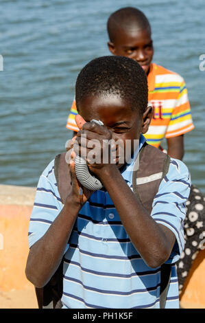 SAINT LOUIS, SENEGAL - Apr 24, 2017: Unbekannter senegalesischen Junge schaut auf die Rohrleitung in der Nähe der Wasser in Saint Louis, eine der größten Städte in Senegal Stockfoto