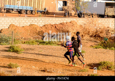 Weg zum Kalvarienberg, SENEGAL - 23.April 2017: Unbekannter senegalesischen drei Männer die Straße entlang laufen. Noch viele Menschen im Senegal leben in Armut Stockfoto