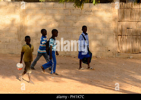 Weg zum Kalvarienberg, SENEGAL - 23.April 2017: Unbekannter senegalesischen kleine Jungen Spaziergang entlang der Straße in der Nähe des Zauns. Noch viele Menschen im Senegal leben i Stockfoto