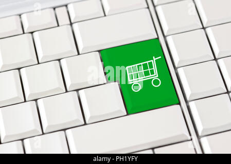 Grüne Einkaufswagen Symbol auf einer Computertastatur konzeptionelle von e-Commerce und on-line-Einkaufen über das Internet Stockfoto