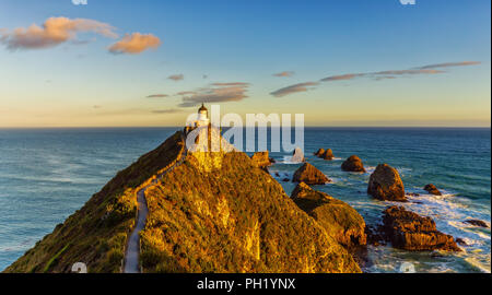 Nugget Point Lighthouse befindet sich an der südöstlichen Küste von Neuseeland und leuchtet schön im Abendlicht. Stockfoto