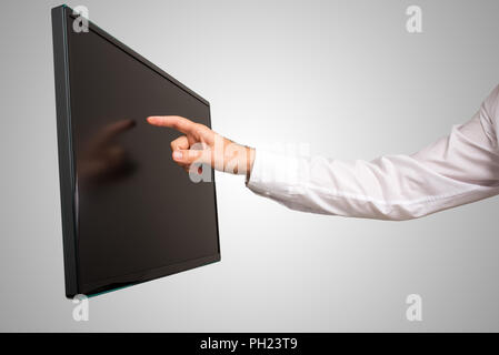 Man Navigieren einer modernen Wand high definition touchscreen computer monitor mit seinem Finger montiert, in der Nähe Blick auf seinen Arm und abgewinkelt. Stockfoto