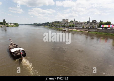 Stadt Saumur, Frankreich. Malerische Aussicht auf ein Boot durch die Loire mit dem Chateau de Saumur oben rechts im Bild. Stockfoto