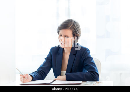 Schreiben Close up Happy Geschäftsfrau Finanzbericht an ihrem Tisch im Büro. Stockfoto