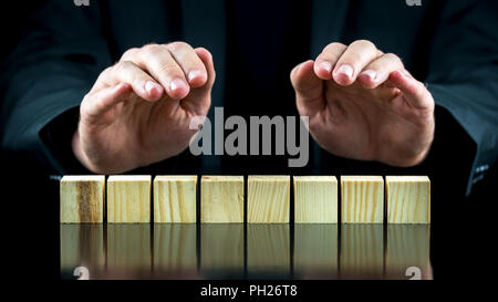 Konzeptionelle Bild mit Schützende Hände über acht Holzwürfel oder Blöcke. Bereit für Ihren Text. Stockfoto