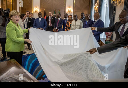 Dakar, Senegal. 29 Aug, 2018. 29.08.2018, Senegal, Dakar: die deutsche Bundeskanzlerin Angela Merkel (CDU) empfängt eine große handgefertigte Schal als Geschenk von Macky Sall (4. von links), Präsident der Republik Senegal. Quelle: Michael Kappeler/dpa Pool/dpa/Alamy leben Nachrichten Stockfoto