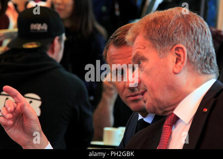 Helsinki, Finnland. August 30, 2018. Der französische Präsident Emmanuel Längestrich (C) und der finnische Präsident Sauli Niinistö (R), eine Tasse Kaffee in einem kleinen Marktplatz Cafeteria nach ihrer gemeinsamen Pressekonferenz. Credit: Taina Sohlman/Alamy leben Nachrichten Stockfoto