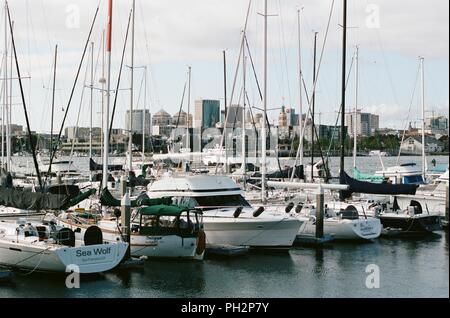 Segelboote und Motorboote in Alameda Marina sichtbar sind, mit der städtischen Skyline von Oakland, Kalifornien im Hintergrund sichtbar, Alameda Island, Alameda, Kalifornien, 14. Mai 2018. () Stockfoto