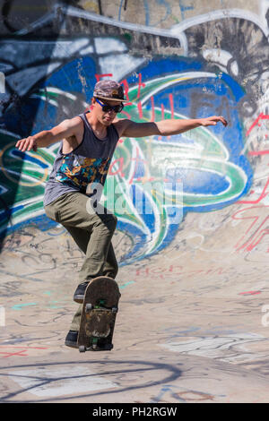 Junger Mann Skateboarder im Riverside River Yard Skateboard Bowl, tolle Herbst, Montana, USA Stockfoto