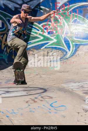 Junger Mann Skateboarder im Riverside River Yard Skateboard Bowl, tolle Herbst, Montana, USA Stockfoto