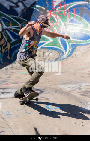 Junger Mann Skateboarder im Riverside River Yard Skateboard Bowl, tolle Herbst, Montana, USA Stockfoto