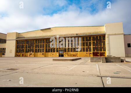 Abblätternde gelbe Farbe auf die großen Türen von einem Flugzeug hangar Gebäude an der verstorbene Alameda Naval Air Station (NAS), einem ehemaligen US Navy Base auf Alameda Island, Alameda, Kalifornien, 13. August 2018. () Stockfoto