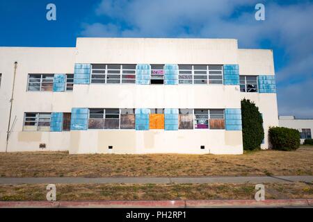 Ehemalige Kaserne Gebäude mit Graffiti und bestieg, um Windows auf die verstorbene Alameda Naval Air Station (NAS), einem ehemaligen US Navy Base auf Alameda Island, Alameda, Kalifornien, 13. August 2018. () Stockfoto