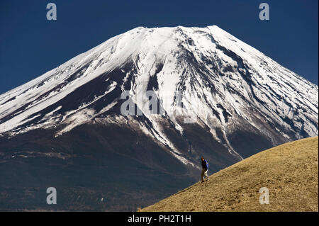 Ein Mann auf einem kleinen Hügel in der Nähe von Mt. Fuji entlang spazieren, die Trekker durch Teile der Asagiri Hochebene in der Präfektur Shizuoka in Japan nimmt entfernt Stockfoto