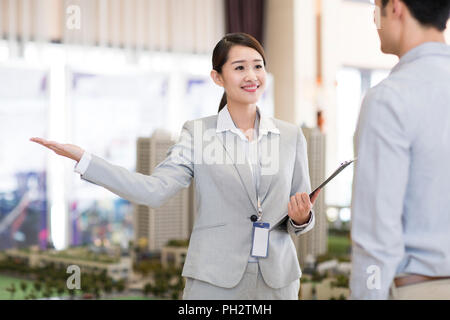 Zuversichtlich Realtor im Gespräch mit Kunden Stockfoto