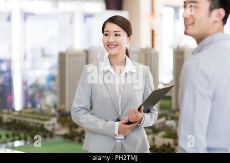 Zuversichtlich Realtor im Gespräch mit Kunden Stockfoto