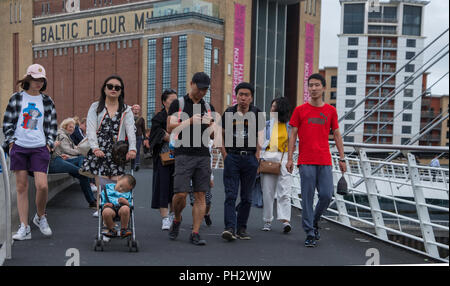 Fußgänger auf der Millennium Bridge über den Fluss Tyne. Stockfoto