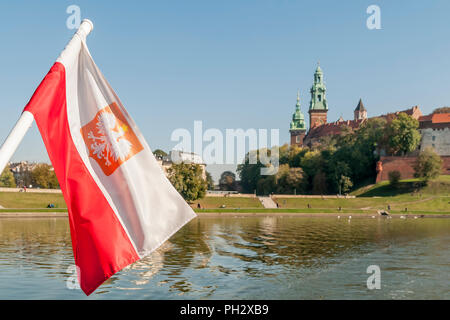 Die polnische Flagge weht auf der Weichsel mit dem Zentrum von Krakau im Hintergrund, Polen Stockfoto