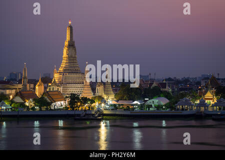 Schöne Aussicht von lit Wat Arun Tempel neben dem Chao Phraya Fluss in Bangkok, Thailand, in der Dämmerung. Stockfoto