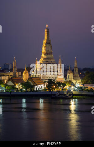 Schöne Aussicht von lit Wat Arun Tempel neben dem Chao Phraya Fluss in Bangkok, Thailand, in der Dämmerung. Stockfoto