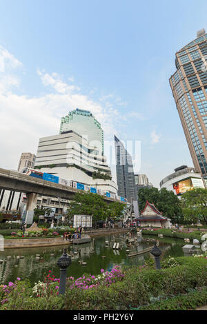 Blick auf einen Teich an der Benchasiri Park, modernen Gebäuden und eine Skytrain in der Innenstadt von Bangkok, Thailand. Stockfoto