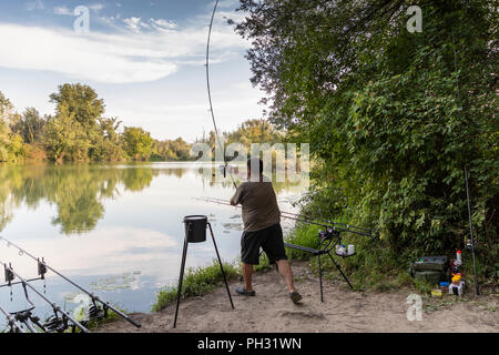 Fischer auf einem See in Karpfen angeln Aktion Stockfoto