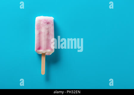 Erdbeeraroma popsicle auf einem blauen Hintergrund Stockfoto