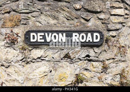 Alte Straßenschild für Devon Straße in Salcombe montiert auf alten Steinmauer Stockfoto