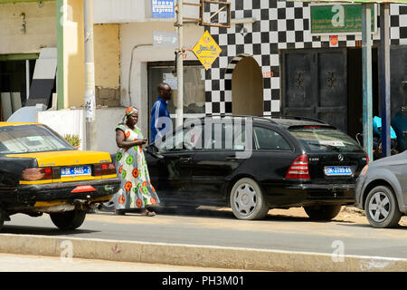 DAKAR, SENEGAL - Apr 27, 2017: Unbekannter senegalesische Frau Spaziergänge zwischen den Autos in Dakar, der Hauptstadt Senegals Stockfoto