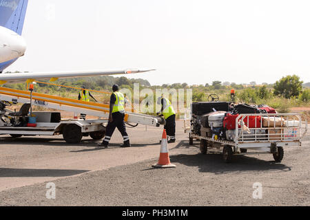 ZIGUINCHOR, SENEGAL - Apr 28, 2017: Unbekannter senegalesischen Männer arbeiten im Kofferraum auf dem Flughafen von Ziguinchor im Senegal Stockfoto