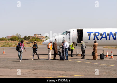 ZIGUINCHOR, SENEGAL - Apr 28, 2017: Unbekannter senegalesischen Fahrgäste stehen in der Nähe des Flugzeugs auf dem Flughafen von Ziguinchor im Senegal Stockfoto